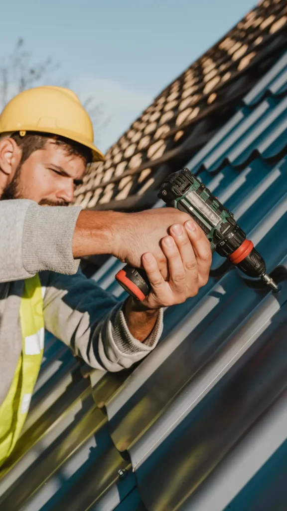 man fixing a metal roof on a house